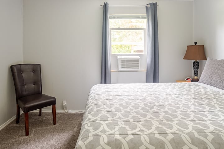 Queen bed, 2 nightstands, chair, small luggage  rack, ironing board behind door