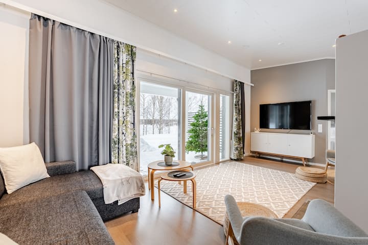 Olohuoneesta on näkymä joelle suurista ikkunoista.