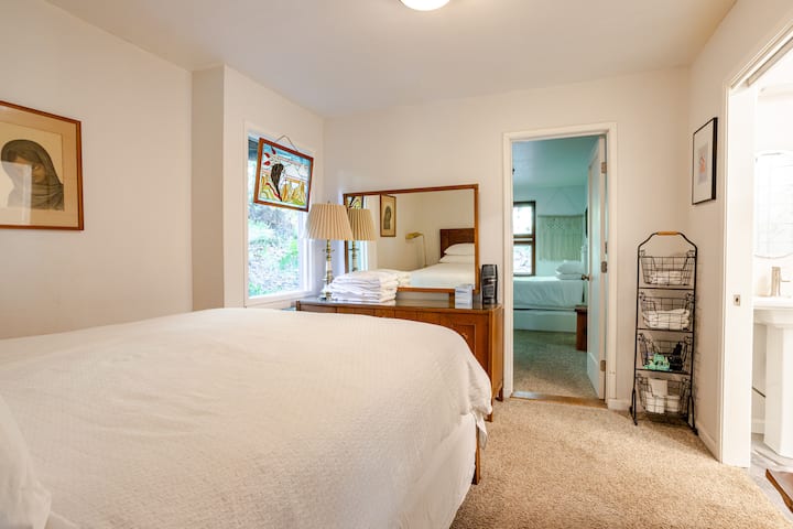 Tienes que caminar por el primer dormitorio con la cama tamaño queen para llegar al dormitorio adjunto con dos camas individuales.  El dormitorio con la cama tamaño queen tiene un baño adjunto con ducha.