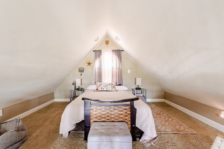 Charming loft space with a comfortable full-size bed and a bird’s-eye view of the living area below.