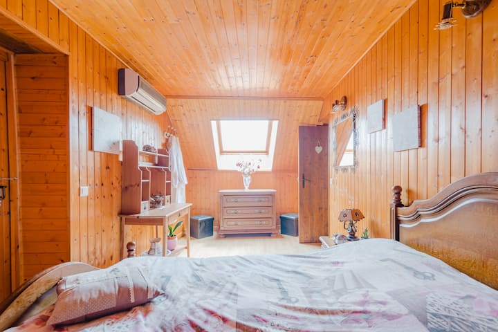 dhomë papafingo me velux të madh dhe perde të errëta.