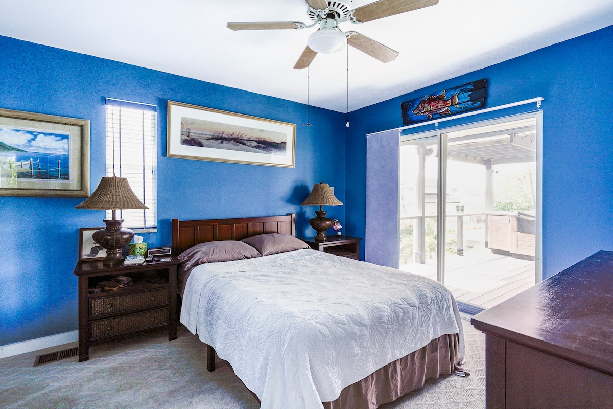 Dormitorio principal con cama tamaño queen.  Llega a la parte trasera del lanai de arriba.  