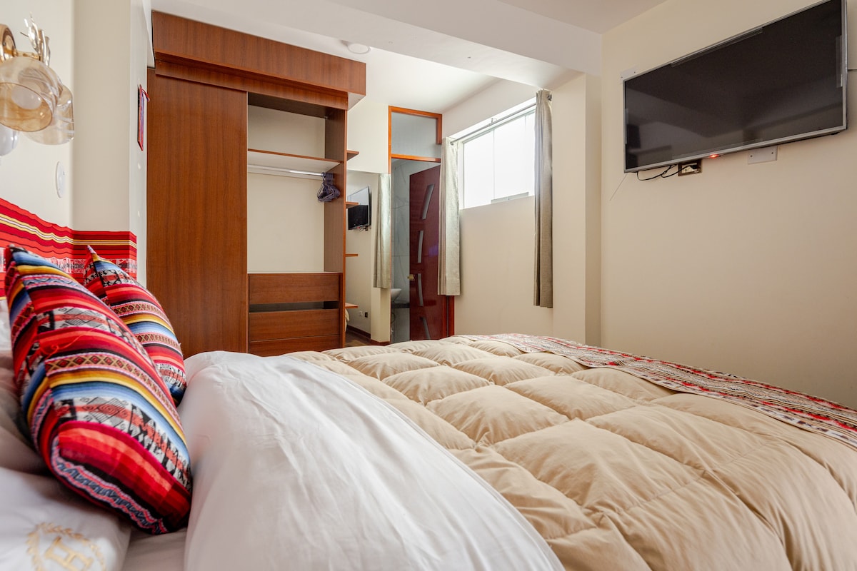 غرفة نوم عصرية مع سرير بحجم كوين ومرتبة مريحة وبطانيات دافئة وخزائن ملابس مدمجة وتلفزيون وحمام خاص. مسكن دافئ وأنيق ومرحب به، مصمم لتوفير راحة أفضل.