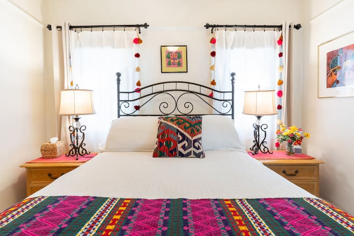 Chumba cha kulala cha wageni kilicho na meza za mwisho zilizo na hifadhi na taa.