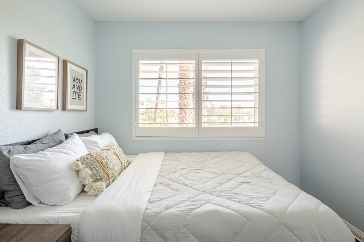 Upstairs guest bedroom with queen size mattress, ceiling fan, and golf course views.