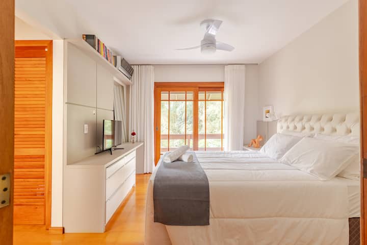 带阳台的主卧套房，配有标准双人床。