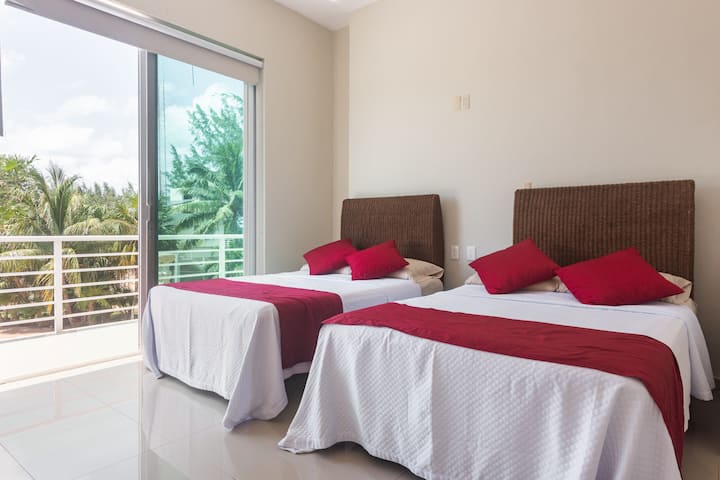 Otra habitación con 2 camas dobles, baño privado y terraza y aire acondicionado.