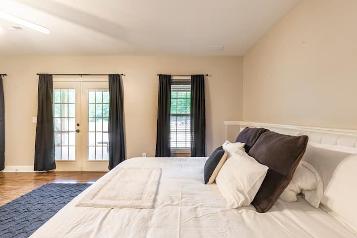 Großes Schlafzimmer mit Kingsize-Doppelbett, Schlafnummer, begehbarem Kleiderschrank und angeschlossenem Badezimmer.