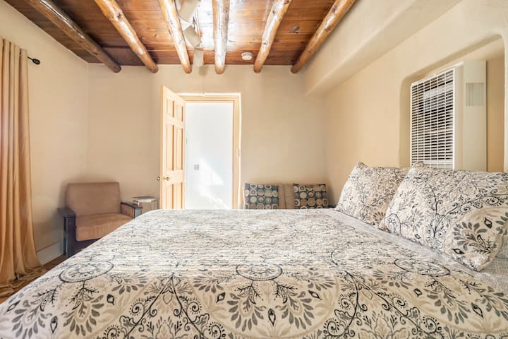 Chumba cha kulala cha malkia wa kati kilicho na sofa na mlango wa pazia.