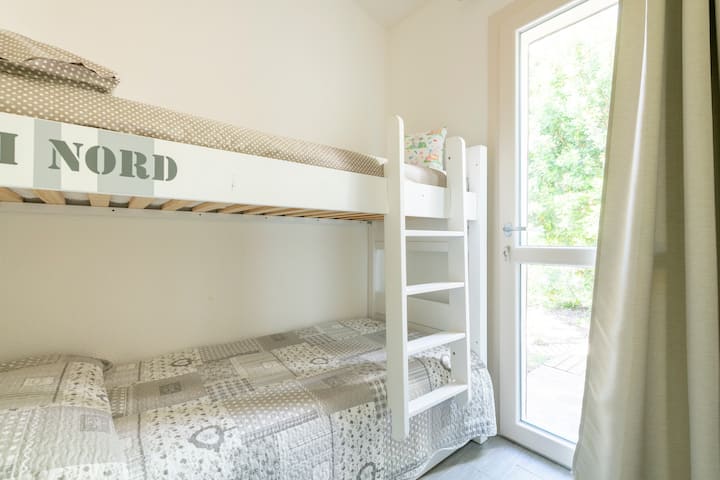 Chambre avec lit superposé et porte fenêtre à l'arrière du jardin