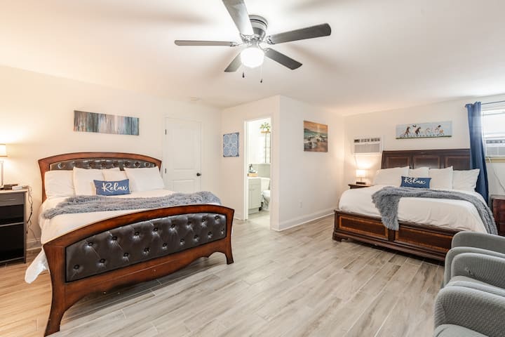 Profitez du confort et de la commodité de cette grande chambre avec deux lits queen, une décoration confortable et un accès direct à une salle de bain privée, idéale pour les familles ou les petits groupes.