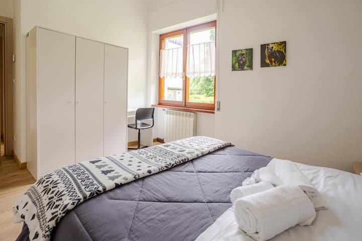 宽敞明亮的卧室，采用山区风格，配有舒适的标准双人床。 配有大衣柜和书桌，非常适合工作或学习，让您完全放心。