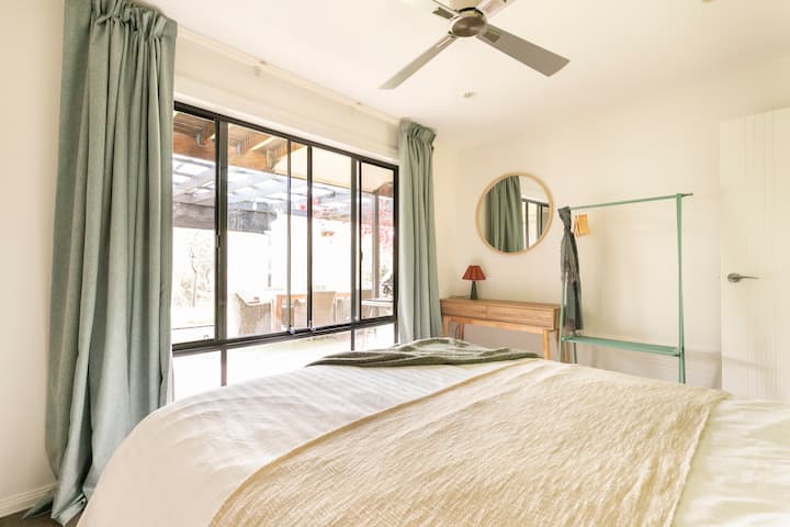 The large window ensures the bedroom feels airy and light-filled. 