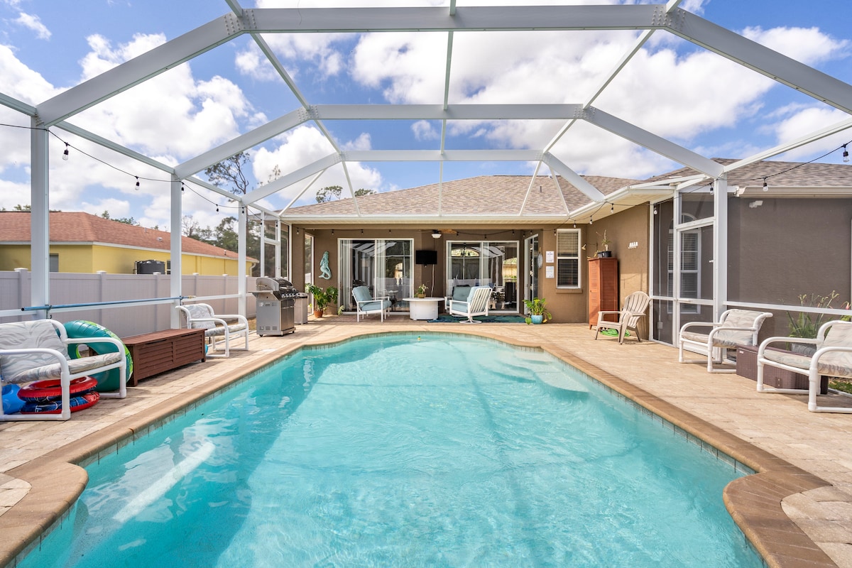 A spacious pool deck is showcased, featuring a heated saltwater pool surrounded by comfortable outdoor seating. A screened enclosure allows natural light to fill the area, while the exterior walls provide a neutral backdrop. The setting invites relaxation and leisure.