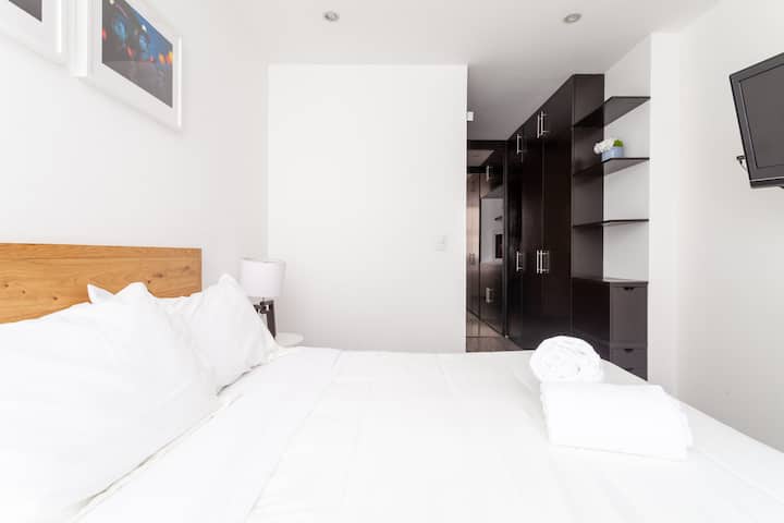 Dormitorio principal con baño privado y TV