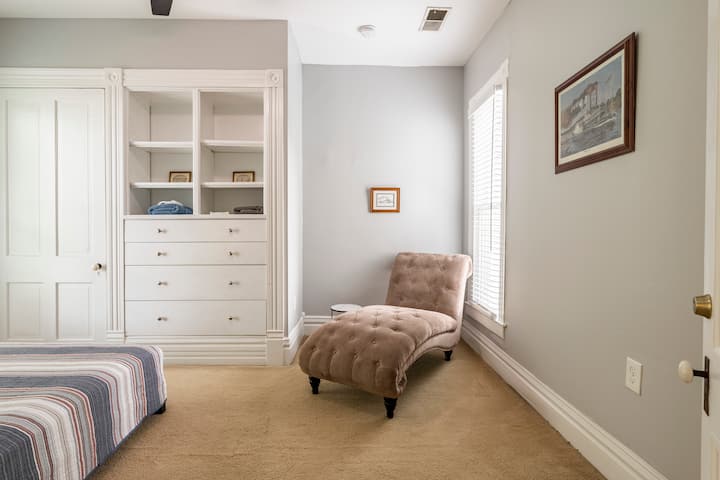 Chambre queen size avec encastré et chaise longue.