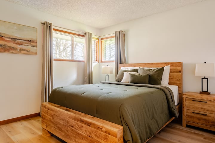 ห้องนอน 1 พร้อมเตียงควีนไซส์และผ้าม่านสีเข้มในห้อง