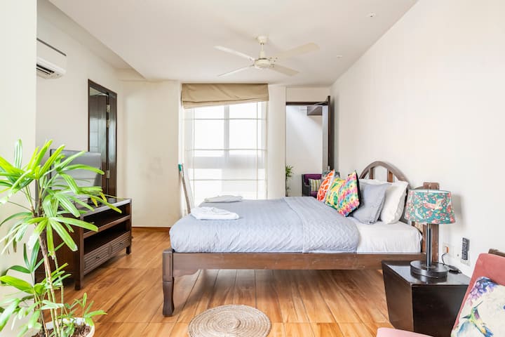 Una camera da letto luminosa e spaziosa con lenzuola di alta qualità, angoli estetici accoglienti e luce solare che filtra attraverso grandi finestre.