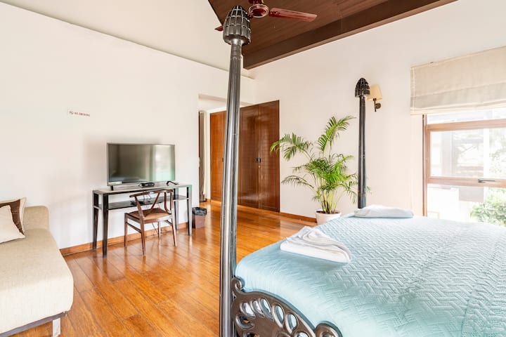 Una bella camera da letto soleggiata con lenzuola di alta qualità, angoli accoglienti, TV e un incantevole angolo lettura vicino alla finestra.