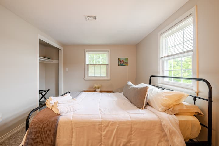 Dormitorio en la planta superior con una cama tamaño queen y una ventana que da al agua. 