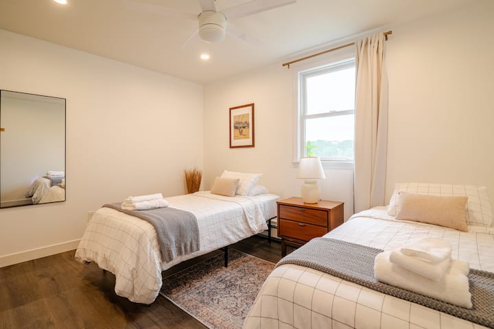 Dormitorio en la planta baja con dos camas individuales y vista al agua. 