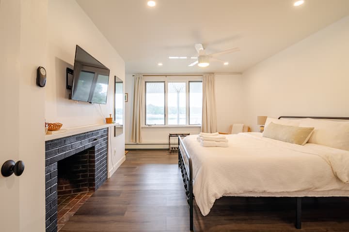 Dormitorio principal en el piso inferior con cama tamaño king. Incluye televisor inteligente, entrada privada y vistas al agua. 