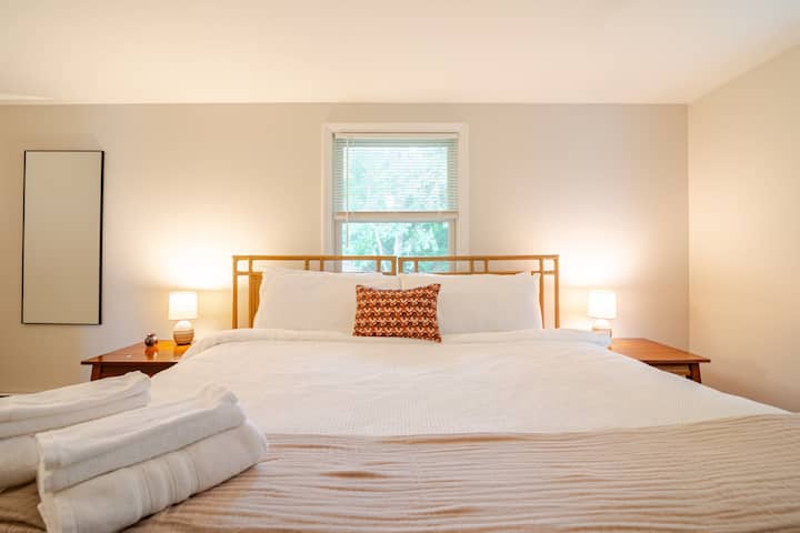Dormitorio principal en la planta superior con una cama tamaño king y baño completo adjunto. 