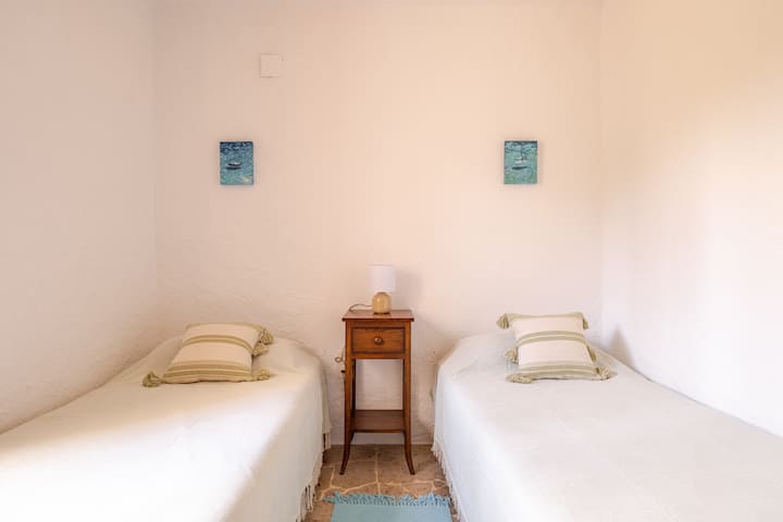 Soba s dva odvojena kreveta s pogledom na vrt. Opremljen ventilatorom. 