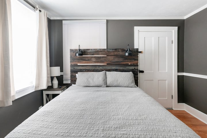 Queen bed, TV, wardrobe, and room darkening shades in room