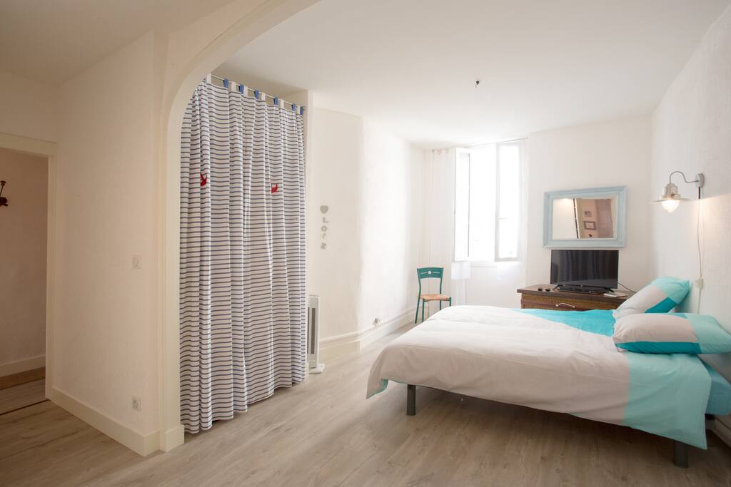 La chambre avec lit double et plusieurs rangements.
