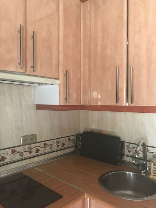 Cocina equipada con vitrocerámica, microondas, nevera y tostadora