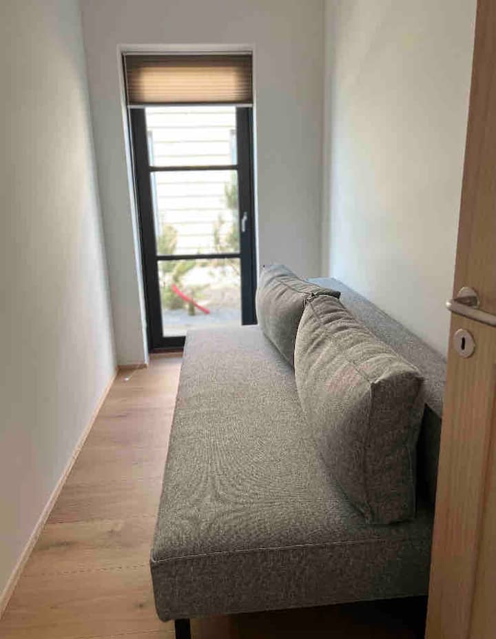 غرفة نوم 3 مع سرير أريكة لشخصين ومخرج خاص إلى الحديقة.