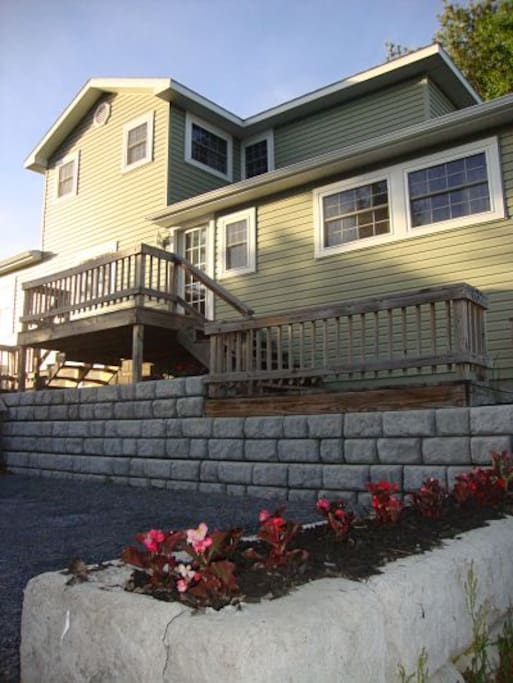 A sizable parking area allowing three to four cars is surrounded by beautiful stonework with built-in flower boxes.