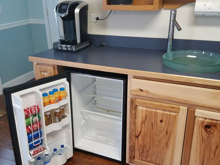 A Keurig and a refrigerator stocked with complimentary drinks are readily at hand
