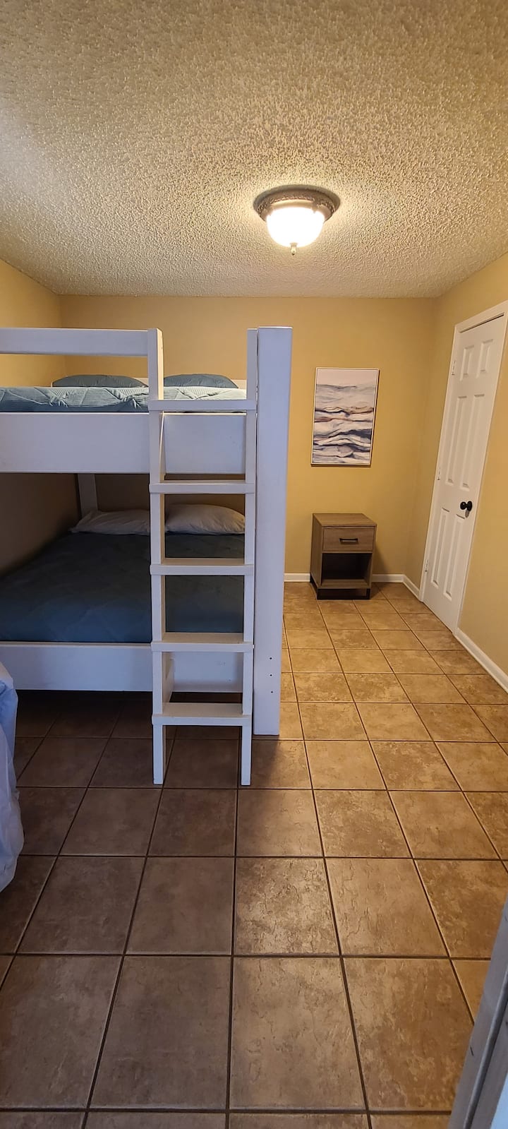 Спалня на долния етаж с две двойни легла точно до всекидневната. 