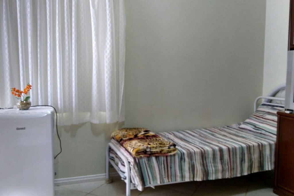 Distribuição das camas e geladeira no quarto