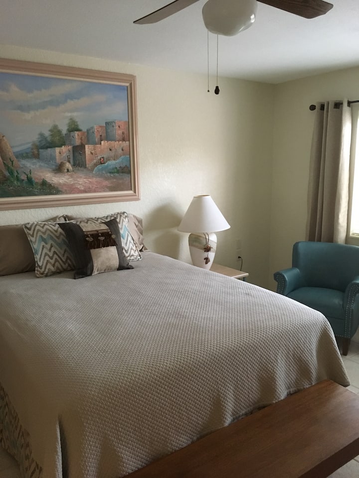 Tretia spálňa (izba Pueblo založená na umeleckých dielach) má manželskú posteľ, stoličku na čítanie, komodu, šatník a pekný výhľad na zadnú terasu.