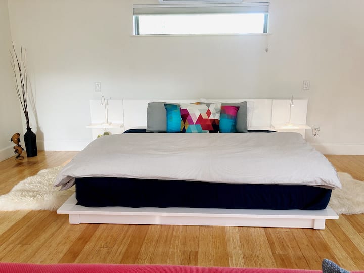 Dormitorio principal con cama tamaño king con zona de estar y televisión. Baño privado en la habitación. 