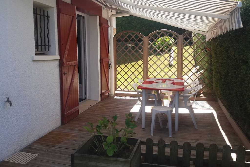 terrasse en bois avec table et chaises de jardin, store manuel