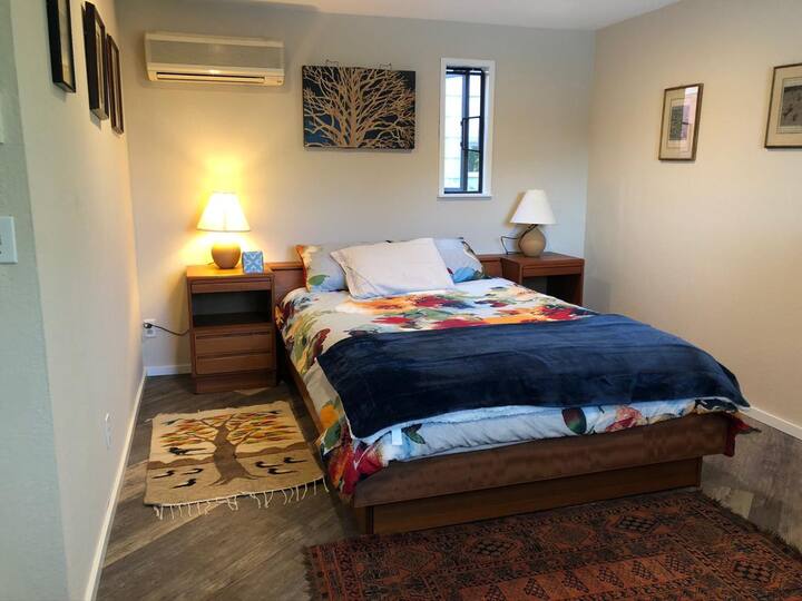 The main bedroom features a queen bed, air conditioning and heating, a work space, and sitting room, as well as views of Lake Union and Mount Rainier. 