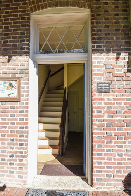 To enter the apartment, the blue door on the left opens to the stairs leading to the upstairs apartment