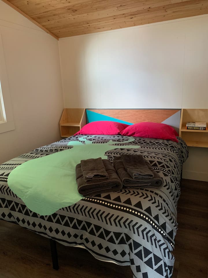 Third bedroom with queen bed and closet. Note: Bedroom walls are loft style and do not extend to the open air vaulted ceiling.