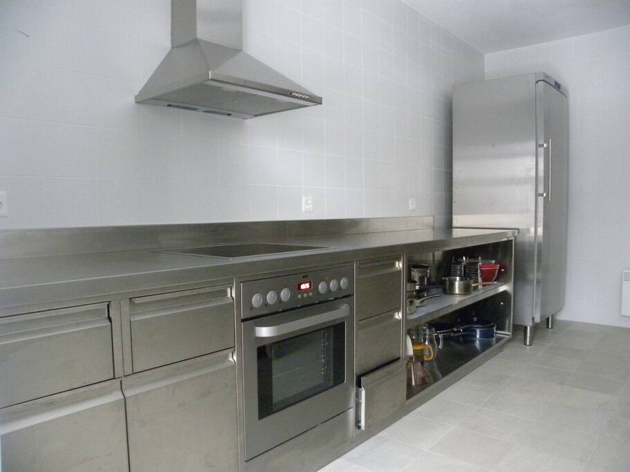 Moderne Chromstahlküche mit leistungsfähigem Geschirrspüler, Backofen, Kühlschrank