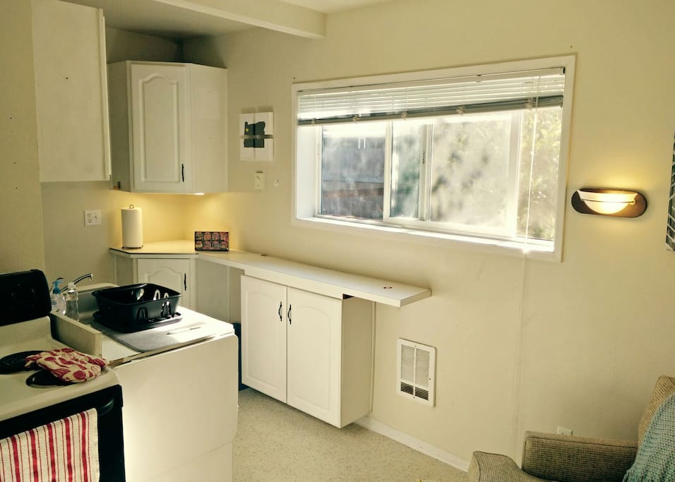 Looking from entry towards small kitchen space. The counters can be extended next to the stove for more space or a small table for two.