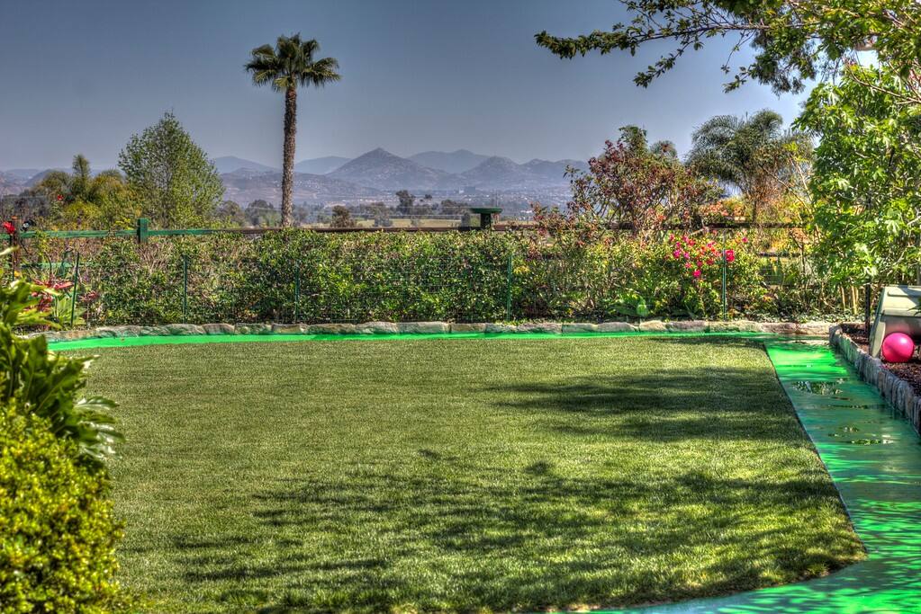 Kids dream yard with riding track, playhouse, climbing structures, & plenty of things to ride.