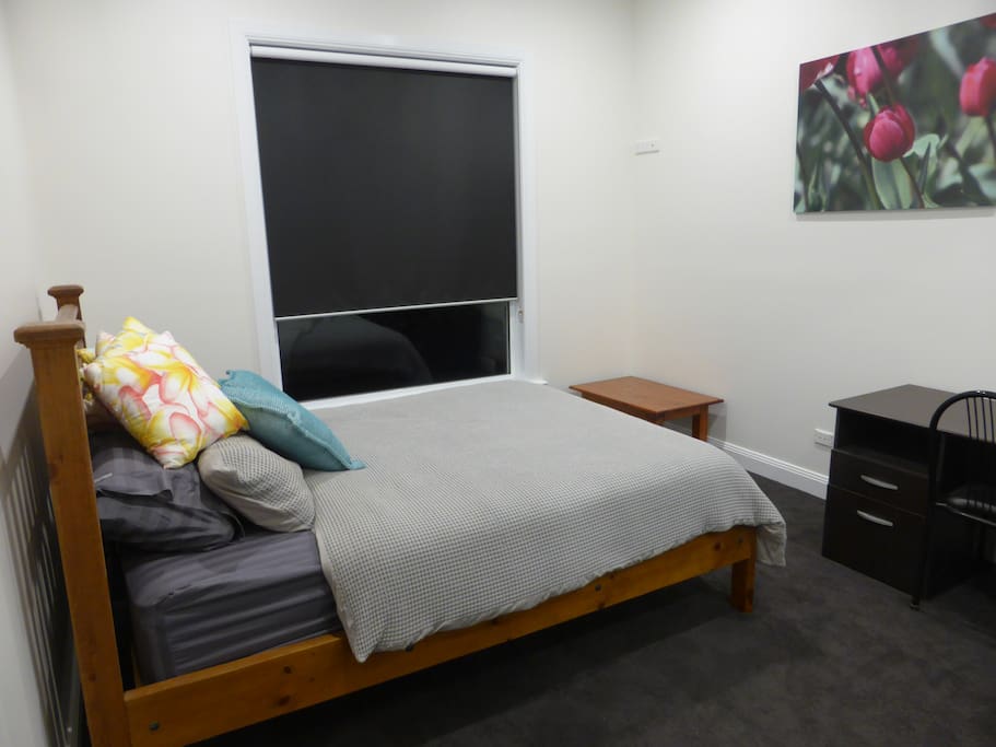 Large bedroom with queen bed, hanging space and a desk. This room faces east and is filled with beautiful morning sun from the moment you open the blinds