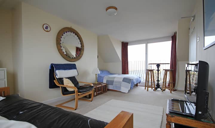 在我们的高桌和凳子上享用咖啡，俯瞰港口的美景。