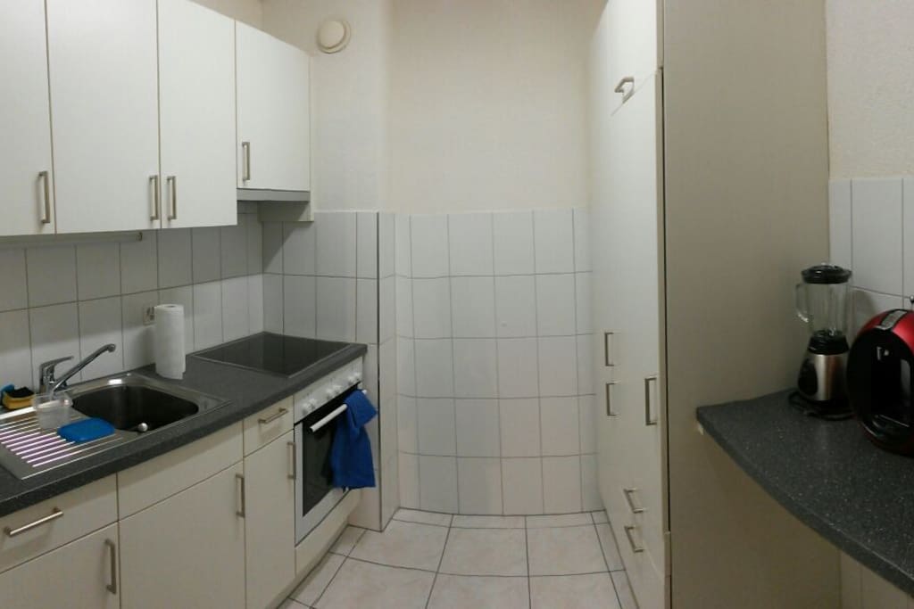 Kitchen with big fridge, coffee machine, kettle and blender.