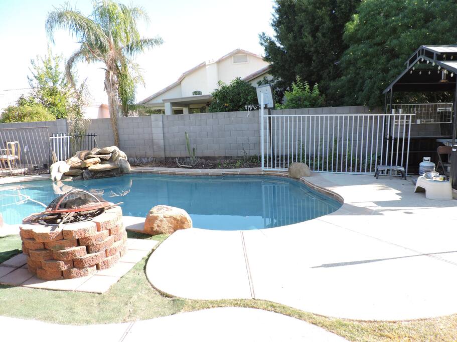 Backyard. Lighted pool and wood-burning fire pit.