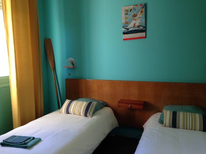 La chambre bleue : lits jumeaux et porte fenêtre donnant sur la véranda. 